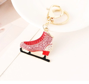 Close-up of sparkling rhinestone ice skate keychain with red enamel and gold plating