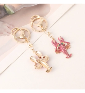 Detail of pink enamel lobster keychain with sparkling rhinestones and golden metal ring