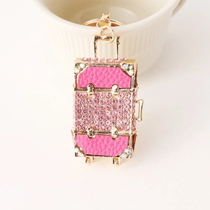Rose pink suitcase keychain with rhinestones and gold-tone metal accents for bags