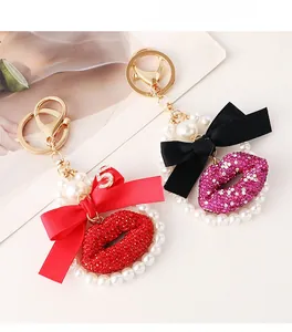 Detail of red and pink crystal-studded lip keychains with satin bows and pearl rings