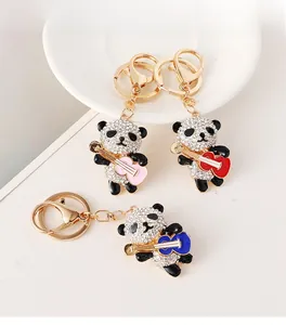Close-up of guitar-playing panda keychains with sparkling rhinestones and colorful enamel