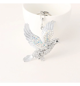 Close-up of silver pigeon keychain featuring sparkling white and colorful AB rhinestones