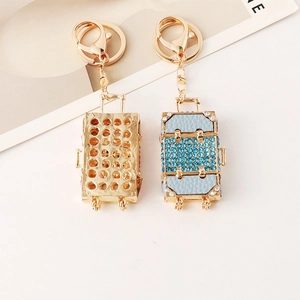 Sparkling rhinestone luggage keychain in gold and light blue finish with lobster clasp