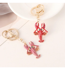 Detail view of red and pink lobster keychains with vibrant enamel finish and gold ring