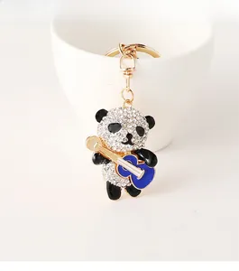 Close-up of cute panda keychain with rhinestones and a blue guitar charm accessory