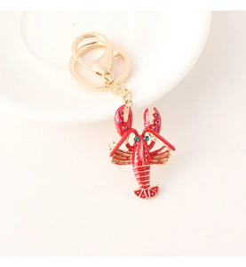 Close-up of a red enamel lobster keychain with sparkling rhinestones and gold accents