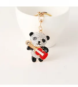 Detail of crystal panda keychain with red guitar and golden lobster clasp
