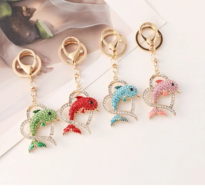 Detailed close-up of four crystal dolphin heart keychains in blue, red, pink, and green