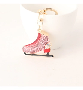 Close-up of ice skate keychain with pink and red rhinestones and golden metal hardware