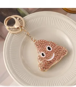Détail d'un porte-clés émoji crotte en strass marron avec fermoir mousqueton doré