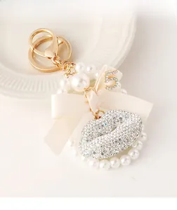 Detailed view of luxury keychain with rhinestone lips, ribbon bow, pearls and number 5 charm
