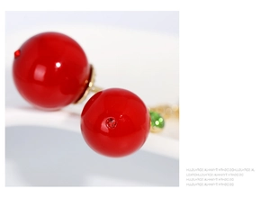 Vue macro de boucles d'oreilles double perle rouge brillant avec détails dorés
