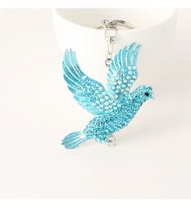 Detail of blue bird keychain showing shimmering rhinestones and silver metal hook