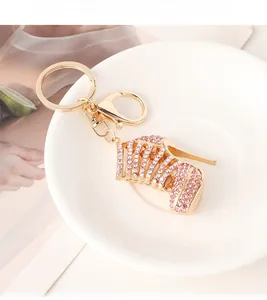 Close-up of pink crystal stiletto shoe keychain with gold plating on a white plate