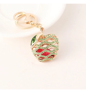 Macro detail of apple keychain with green rhinestones and golden metal hardware