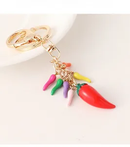 Detailed view of handmade red chili keychain with colorful mini pendants and gold clasp