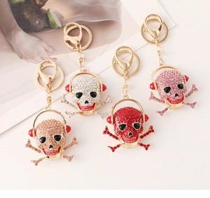 Detailed close-up of skull headphone keychains in multiple metallic rhinestone finishes