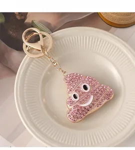 Porte-clés émoji crotte en strass roses avec fermoir doré sur coupelle déco