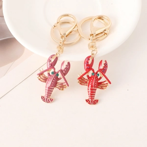 Red and purple enamel lobster keychains with sparkling rhinestones and gold-plated finish