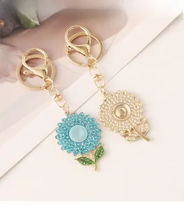 Detailed close-up of blue rhinestone and golden sunflower keychain charms for bags
