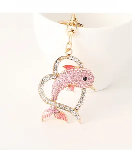 Detail of dolphin heart keychain with pink rhinestones on a gold alloy frame