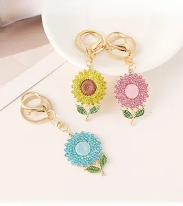 Detailed close-up of crystal sunflower keychains in yellow, pink and blue with gold lobster clasp