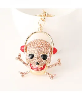 Macro detail of skull keychain with champagne rhinestones and red headphones on white cup