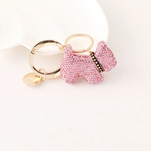 Pink rhinestone puppy keychain with golden clasp and heart detail on white background