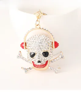 Macro shot of skull keychain with rhinestones and headphones on a white cup edge
