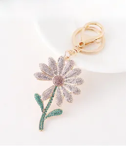 Detailed macro view of golden daisy keychain with pink and white crystal rhinestones