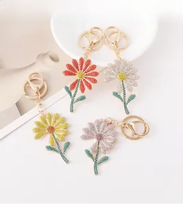Close-up of sparkling rhinestone daisy keychains in red, white, yellow and pink petals