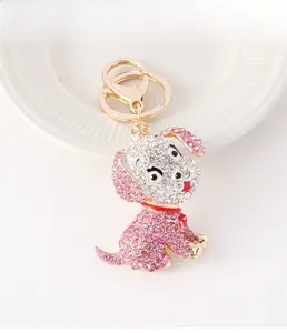 Detail eines süßen rosa-weißen Kristall-Hunde-Schlüsselanhängers mit goldenem Schlüsselring
