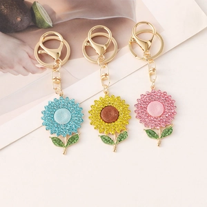 Three colorful sunflower keychains with sparkling rhinestones in pink, blue, and yellow