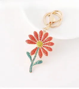 Detailed macro shot of daisy flower keychain with red petals and colorful crystals