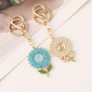Charming sunflower keychains set with blue rhinestones and gold textured metal petals