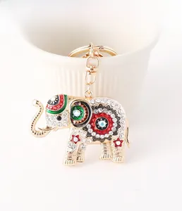 Gros plan d'un porte-clés éléphant avec cristaux blancs et émail coloré sur tasse blanche