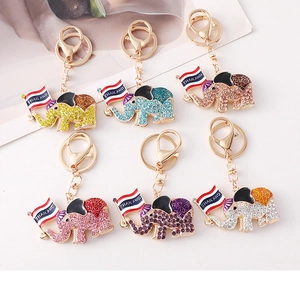 Detail showing various colorful rhinestone elephant keychains with Thailand flags