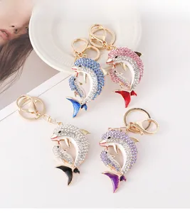 Vue détaillée des porte-clés dauphins en bleu, violet, rose et blanc avec cristaux