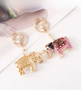 Close-up of elephant keychains with pink crystals and enamel details on a white surface