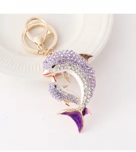 Détail d'un porte-clés dauphin avec strass violets et quincaillerie en émail doré
