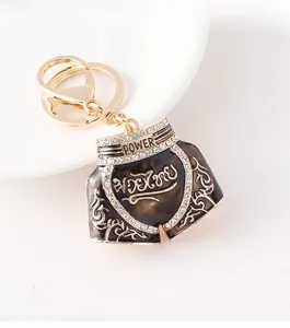Close-up of Muay Thai shorts keychain in brown with gold patterns and crystal accents