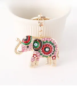 Gros plan du porte-clés éléphant étincelant avec des strass colorés sur métal doré