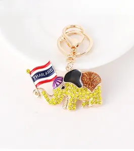 Close-up of golden elephant keychain with yellow rhinestones and Thailand flag detail