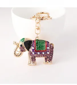Detail of elephant keychain with purple rhinestones and colorful enamel on a white cup