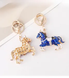 Détail de porte-clés cheval émaillé avec découpes cœur et selle en strass bleu