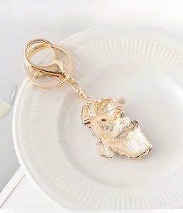 Detailed view of dual-use golden Christmas pin keychain showing lobster clasp and brooch pin