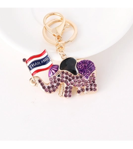 Close-up of golden elephant keychain with purple rhinestones and Thailand flag detail