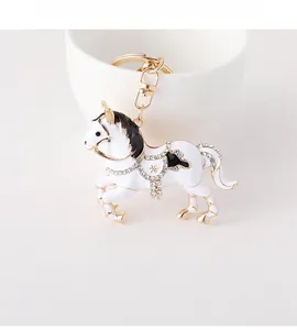 Détail d'un porte-clés cheval doré avec émail blanc et strass brillants incrustés