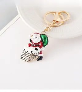 Detail of Christmas Santa climbing chimney keychain with green gift bag and metal lobster clasp