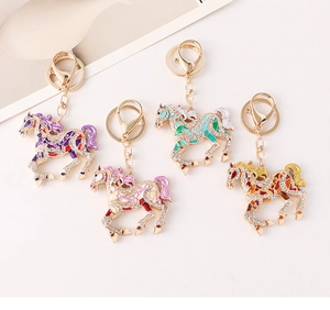 Detail of colorful enamel horse keychains with sparkling crystals in four vibrant colors